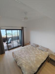 Un dormitorio con una cama y una puerta corrediza de vidrio. en Apartment in flic en Flac, en Flic en Flac