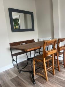 una mesa de madera con 2 sillas y un espejo en The Meads, en Ilfracombe 11 fotos más