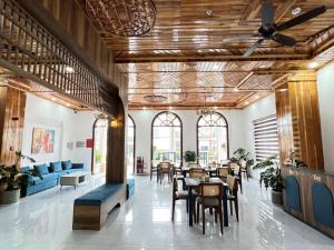 a lobby with tables and chairs in a building at ORCHID Hotel in Da Lat