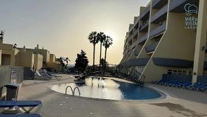 ein Schwimmbad vor einem großen Gebäude in der Unterkunft Mar à Vista Lagos in Lagos