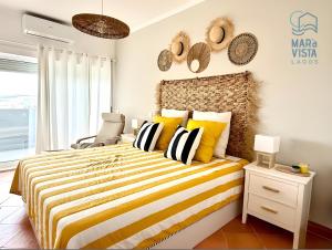 ein Schlafzimmer mit einem Bett mit gelben und schwarzen Kissen in der Unterkunft Mar à Vista Lagos in Lagos + 25 Fotos