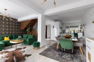a living room with a green couch and a table at Holiday House Rasnov in Râşnov