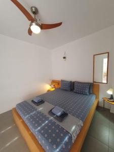 a bedroom with a bed with a ceiling fan at Alquilaencanarias-Medano Los Martines beachfront A in El Médano +12 photos