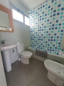 a bathroom with a white toilet and a sink at Alquilaencanarias-Medano Los Martines beachfront A in El Médano