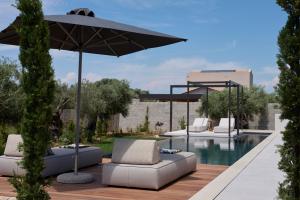 a patio with chairs and an umbrella and a pool at Noero Villas Lefkada in Lefkada