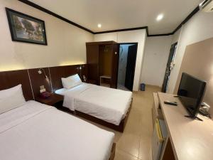 ビエンチャンにあるLucky city hotelのベッド2台と薄型テレビ付きのホテルの部屋