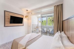a bedroom with a bed and a tv on a wall at Hand Made Suite Costa del Silencio in Costa Del Silencio