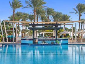 a pool at a resort with palm trees in the background at Rixos Premium Seagate in Sharm El Sheikh