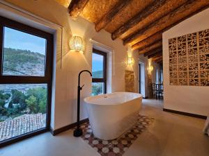 a bath tub in a room with large windows at Apartamentos Rurales LA BUENA ESTRELLA in Alcalá del Júcar +48 photos