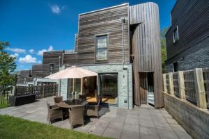 a house with a patio with a table and an umbrella at House 2 in Looe