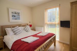 a bedroom with a large bed with two towels on it at House 2 in Looe +16 photos