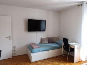 a room with a couch with a tv on the wall at Silvo Apartments in Koper