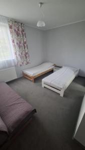 a room with two beds and a window at Gościniec 