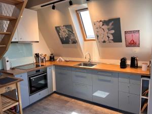 a kitchen with blue cabinets and a sink at Balatinn in Balatonkenese