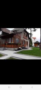 ein großes Haus mit einer Auffahrt davor in der Unterkunft POKÓJ RODZINNY SERCE KRYNICY in Krynica Morska