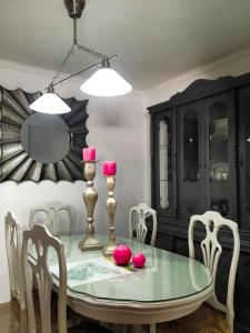 a dining room with a glass table and chairs at Casa Rural Cuevas del Sol in Setenil