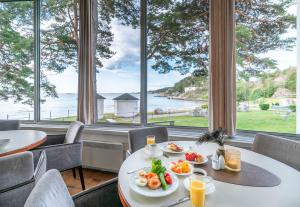 a dining room with a table with plates of food at Strand Hotel Fevik - by Classic Norway Hotels in Grimstad +79 photos