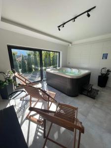 una grande camera con una grande vasca e sedie di ApartView Szkolna Szczyrk by Rent like home a Szczyrk