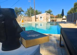 a book sitting on a table next to a swimming pool at Paxos Dream House in Vlachopoulátika +23 photos
