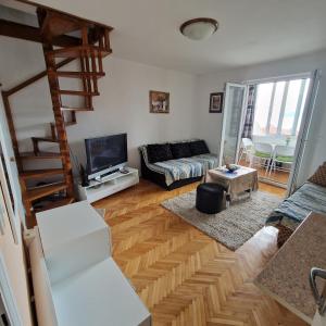 a living room with a couch and a television at Apartman Katarina in Baošići