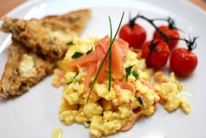 a white plate with scrambled eggs and toast and tomatoes at Ty Boia Bed & Breakfast in St. Davids +19 photos