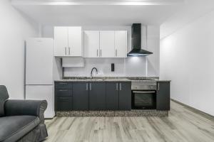 a kitchen with black and white appliances and a couch at Santa Cruz Kiko Residences in Santa Cruz de Tenerife