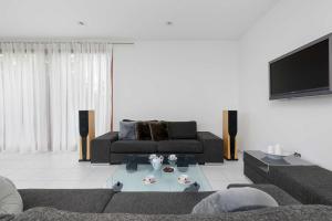 ein Wohnzimmer mit Sofa und Fernseher in der Unterkunft Two-level Modern Apartment with Spacious Terrace - Ideal Place for the Holiday by Noclegi Renters in Wisełka