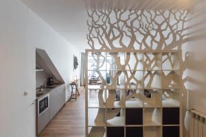 a kitchen with a wooden shelving unit with a tree design on the wall at Art apartment in downtown Porto in Porto