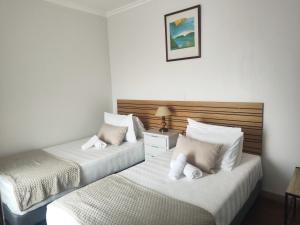 a bedroom with two beds with white pillows at Quinta do Araújo - GuestHouses in Câmara de Lobos