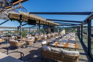 a restaurant with tables and chairs on a balcony at Eurohotel in Lviv
