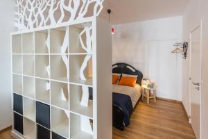 a bedroom with a bed and a wall with white shelves at Art apartment in downtown Porto in Porto