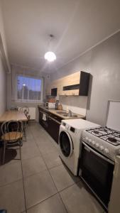 a kitchen with a stove and a washing machine at Gościniec 