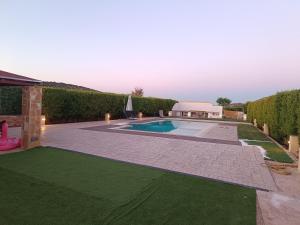 a backyard with a swimming pool and green grass at Evelina's studio in Artemida