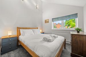 a bedroom with a bed with towels on it at Reading Station - Modern Home with its own Garden Sleeps 6 in Reading