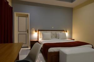 Un dormitorio con una cama, una mesa y una silla. en Hotel Ophelia Lodge, en Port-Gentil