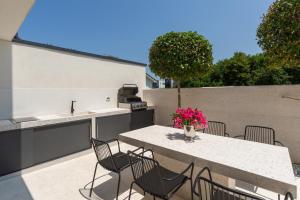 a patio with a table and chairs and a kitchen at Villa Verana with pool in Savudrija