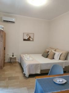 una camera da letto con un grande letto bianco in una stanza di Sunny Patio Studio Corfu ! ad Alepoú