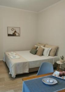 una camera con un grande letto e una sedia blu di Sunny Patio Studio Corfu ! ad Alepoú