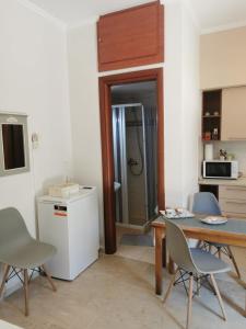 una cucina con tavolo, sedie e frigorifero di Sunny Patio Studio Corfu ! ad Alepoú