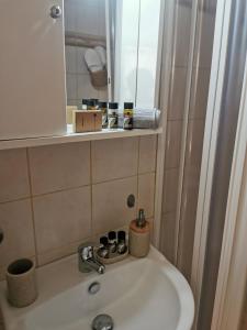 un lavandino in bagno con specchio e doccia di Sunny Patio Studio Corfu ! ad Alepoú Altre 10 foto