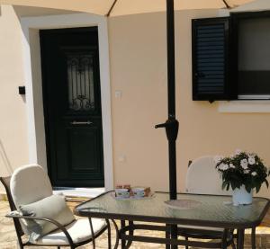 a table and chairs in a room with a green door at Sunny Patio Studio Corfu ! in Alepou