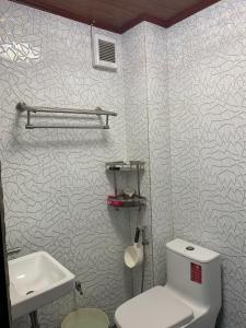 a bathroom with a white toilet and a sink at Cozy Aesthetic 2BR 3 storey Home with Rooftop in San Mateo