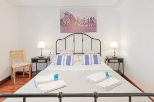 a bedroom with a bed with two tables and a chair at Taosa - baskeyrentals in Zumaia