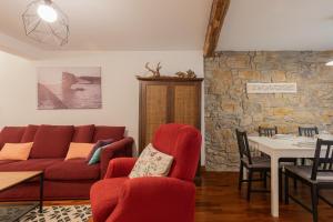 a living room with a red couch and a table at Taosa - baskeyrentals in Zumaia