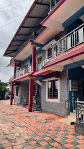 a building with red columns and balconies on it at KK Residences in Madikeri