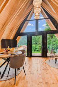 a dining room with a table and chairs and a large window at Cabanele Sașilor in Cisnadioara
