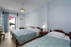 a bedroom with two beds and a balcony at Proteas Hotel in Kamari