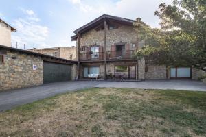 a large brick house with a balcony and a yard at Can Vall Bellver in Bellver de Cerdanya 