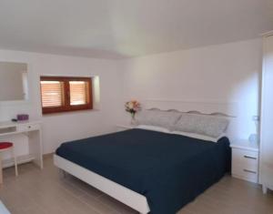 a bedroom with a blue bed in a white room at La Quercia in Altavilla Silentina