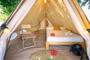 a tent with a bed and a chair in it at Kampaoh Rianxo in Rianjo +23 photos